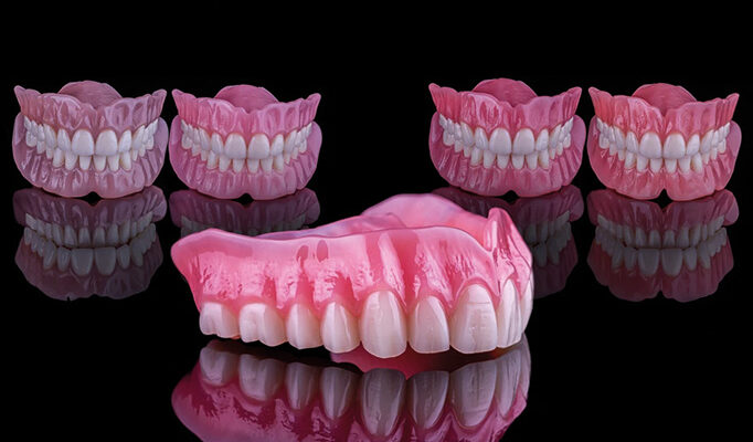 Removable implant dentures against a black background.