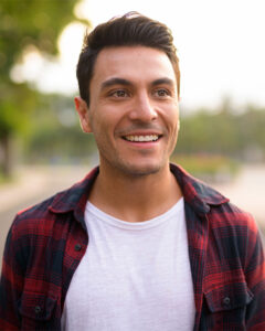 A young man smiling confidently after professional teeth whitening in Oceanside.