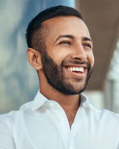 A young man with a bright smile from in-office teeth whitening.