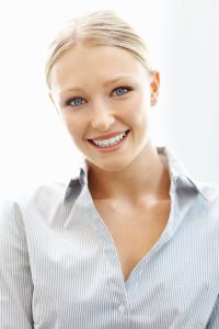 A blonde young woman smiling after professional teeth whitening in Oceanside.