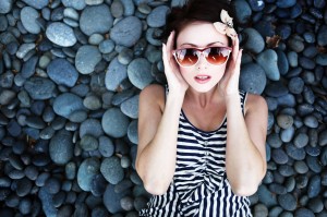 A young woman reclining peacefully on pebbles after recieving sleep apnea treatment in Oceanside.